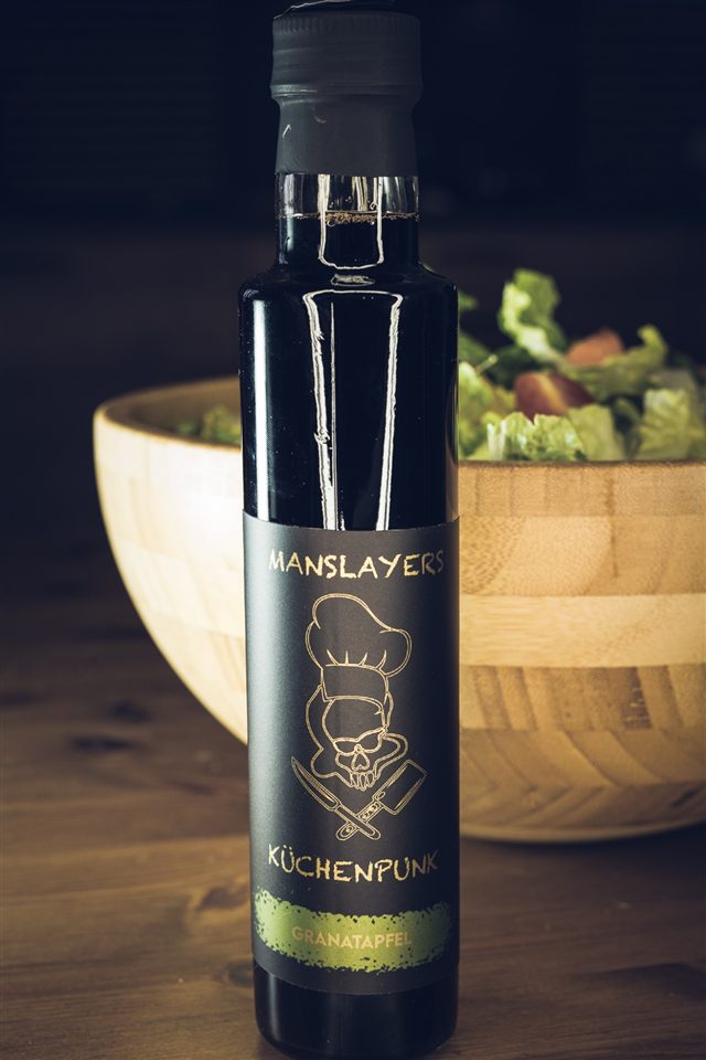 Manslayers Küchenpunk Granatapfel — dunkle Flasche vor einer Salatschüssel